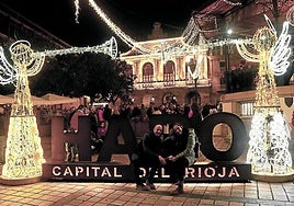 Una familia posa junto a las letras de 'Haro' en la plaza de la Paz tras el encendido.
