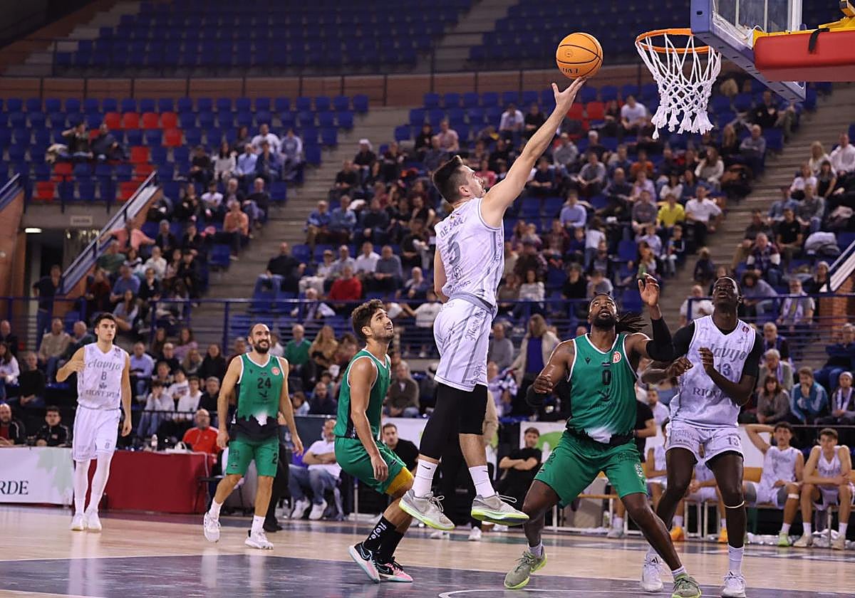 De Pablo entra a canasta ante dos defensas cacereños.