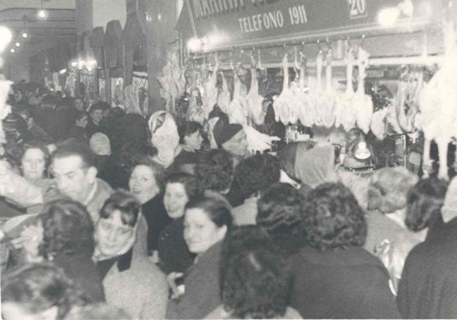 Lla plaza de abastos de la capital llena hasta los topes en vísperas de la Navidad de 1959.