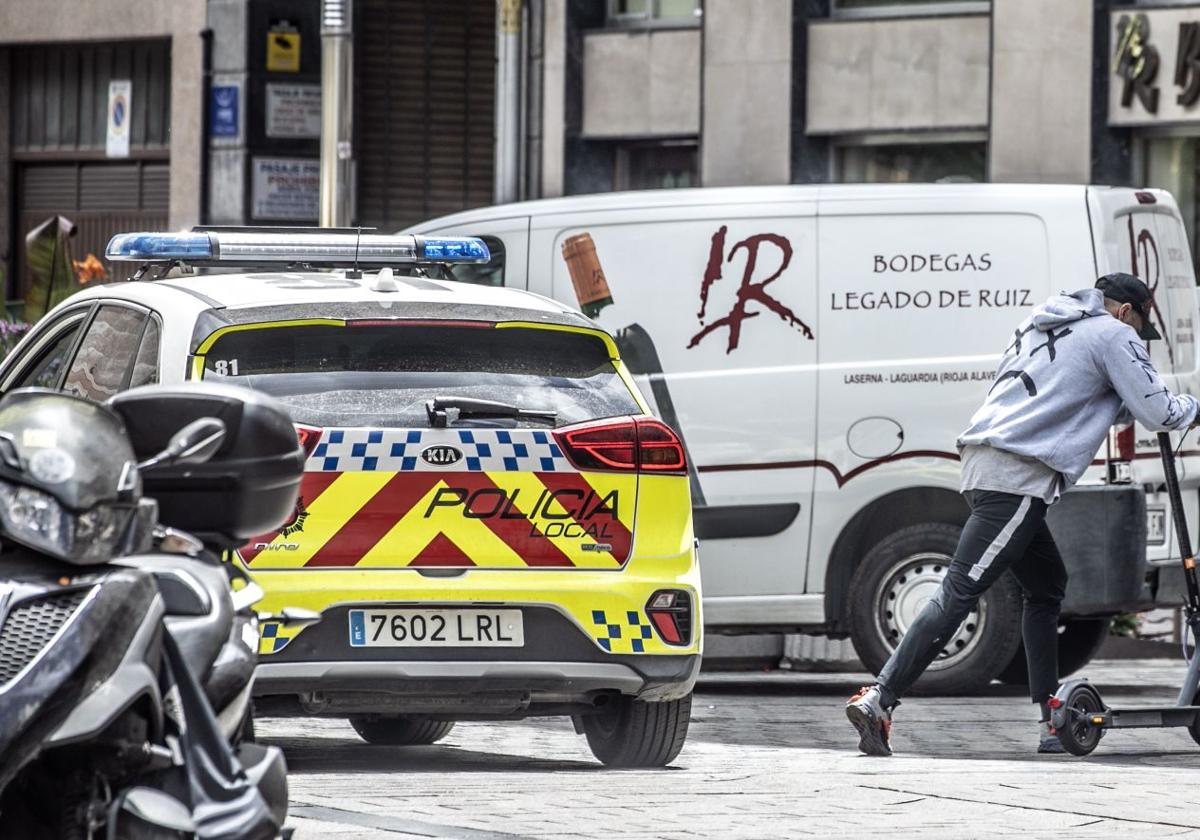 Un usuario de patinete eléctrico se cruza con un vehículo de la Policía Local de Logroño en una imagen de archivo.