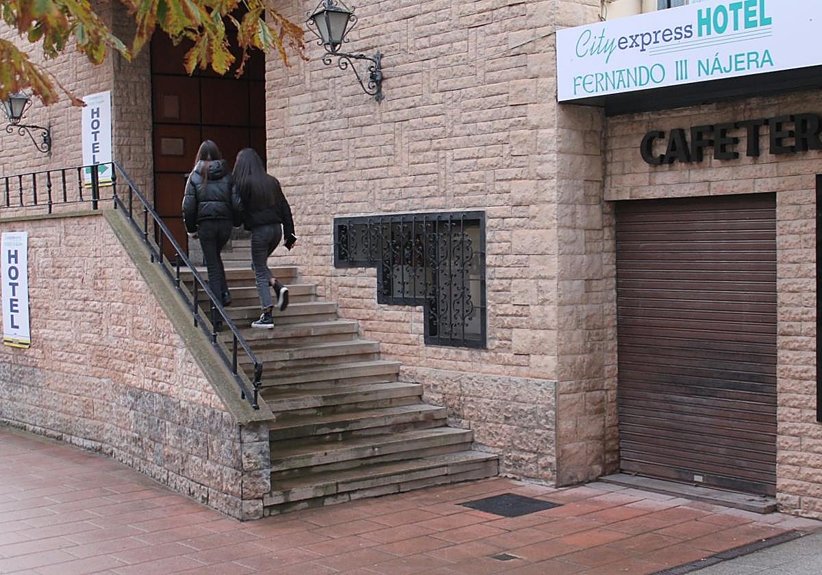 Dos jóvenes se asoman curiosas a la recepción del hotel, todavía cerrado, durante este viernes.