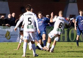 Álvaro pierde la posesión rodeado de tres jugadores del Tudelano durante la mañana de ayer en Isla.