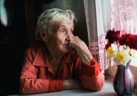 Una mujer mira por la ventana.