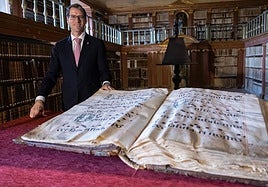 El presidente de La Rioja, Gonzalo Capellán, en la biblioteca de Yuso, junto a uno de los libros cantorales del monasterio.