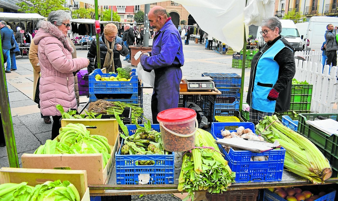 Víctor Comas en su puesto de productos de temporada de la huerta, en el mercadillo de la Plaza del Raso de Calahorra, ayudado por Rita Sota.