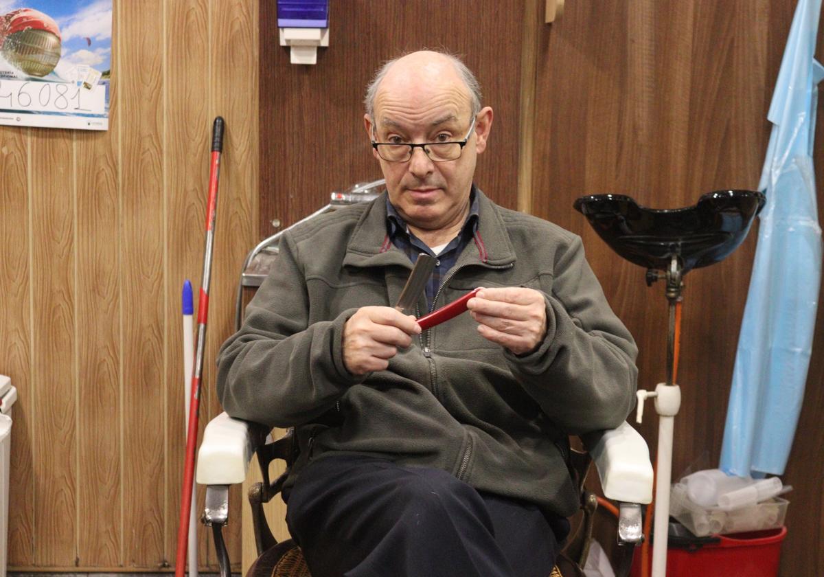 Luis Miguel Alonso, sentado en uno de sus sillones de 1940, sostiene una de sus navaja más antiguas.