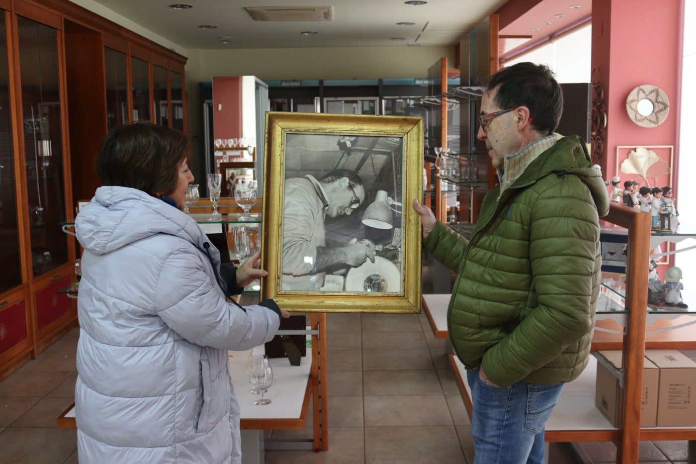 José y Maru Valentín sostienen un cuadro con la imagen de su padre, José Luis, en Cristalerías Salgueiro.