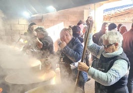 Vecinos y cofrades remueven las grandes cacerolas de habas en El Potro desde el alba.