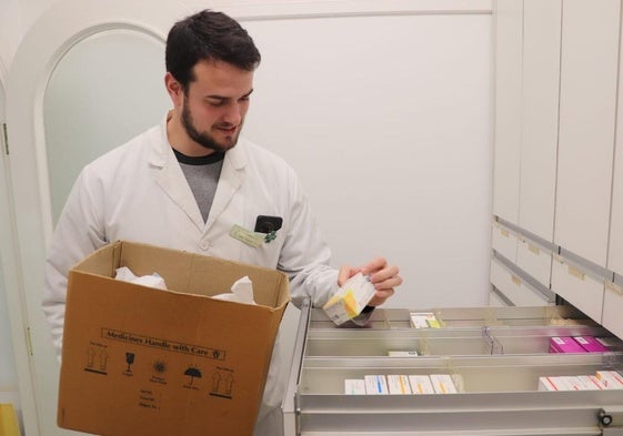 César Palacios prepara una caja con medicamentos en su farmacia de Arnedillo para acudir a los botiquines de Enciso y Munilla.