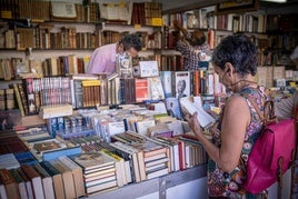 Una mujer consulta un ejemplar en la feria del libro de Logroño.