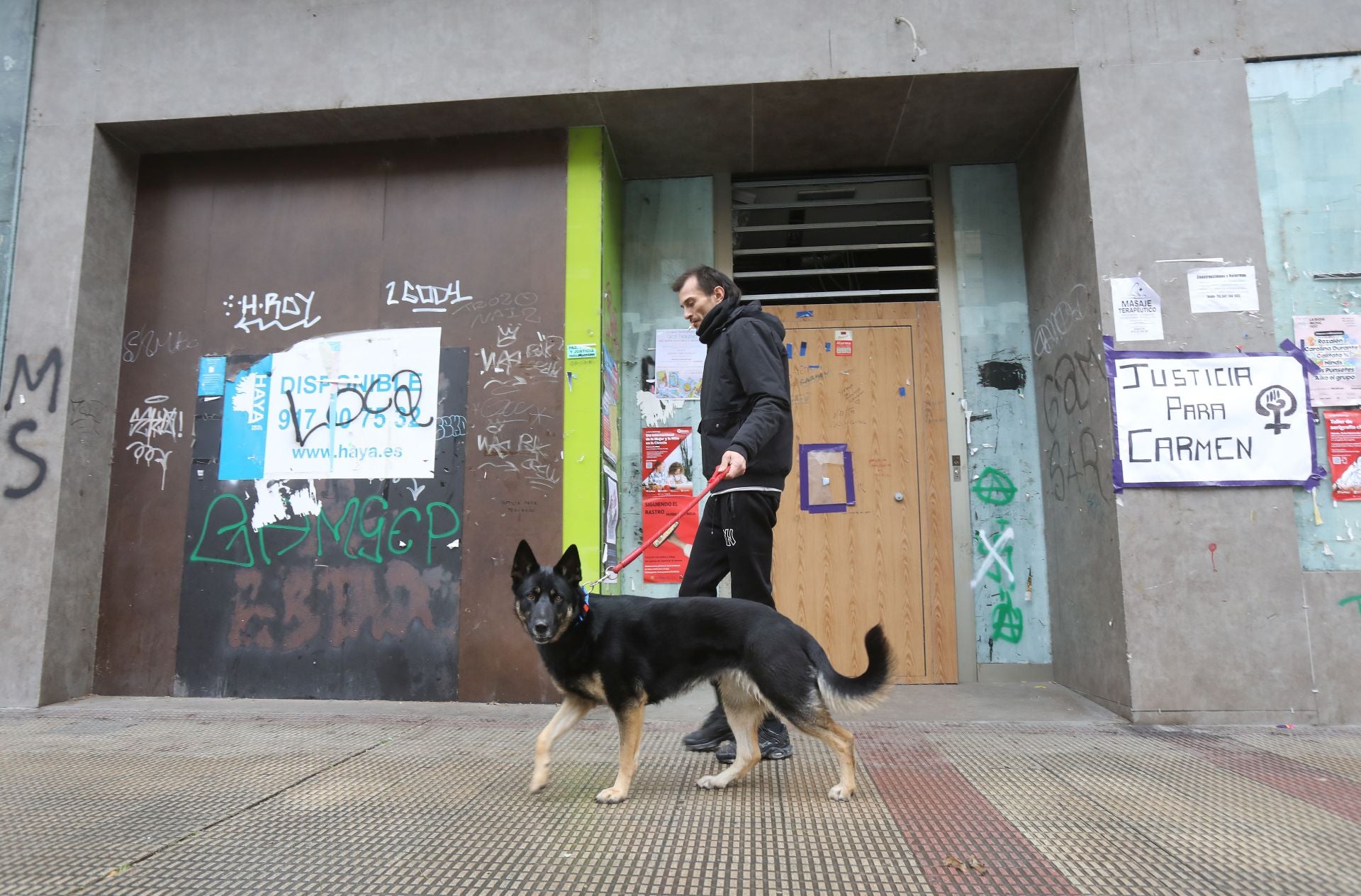 Un hombre y su perro pasan junto a la sucursal de San Millán