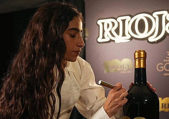 Carolina Yuste firma una de las botellas de Rioja.