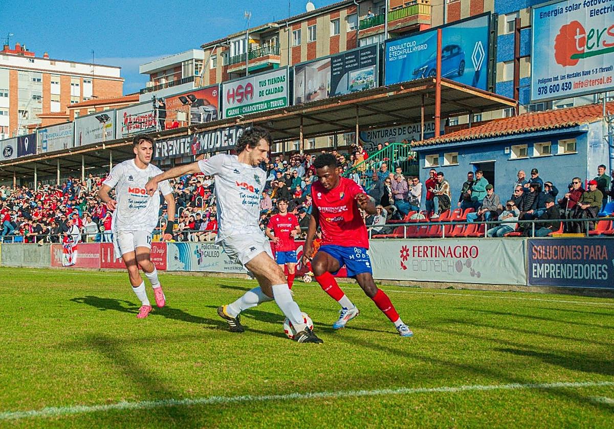 El jugador del Anguiano Héctor intenta zafarse de un defensor turolense.