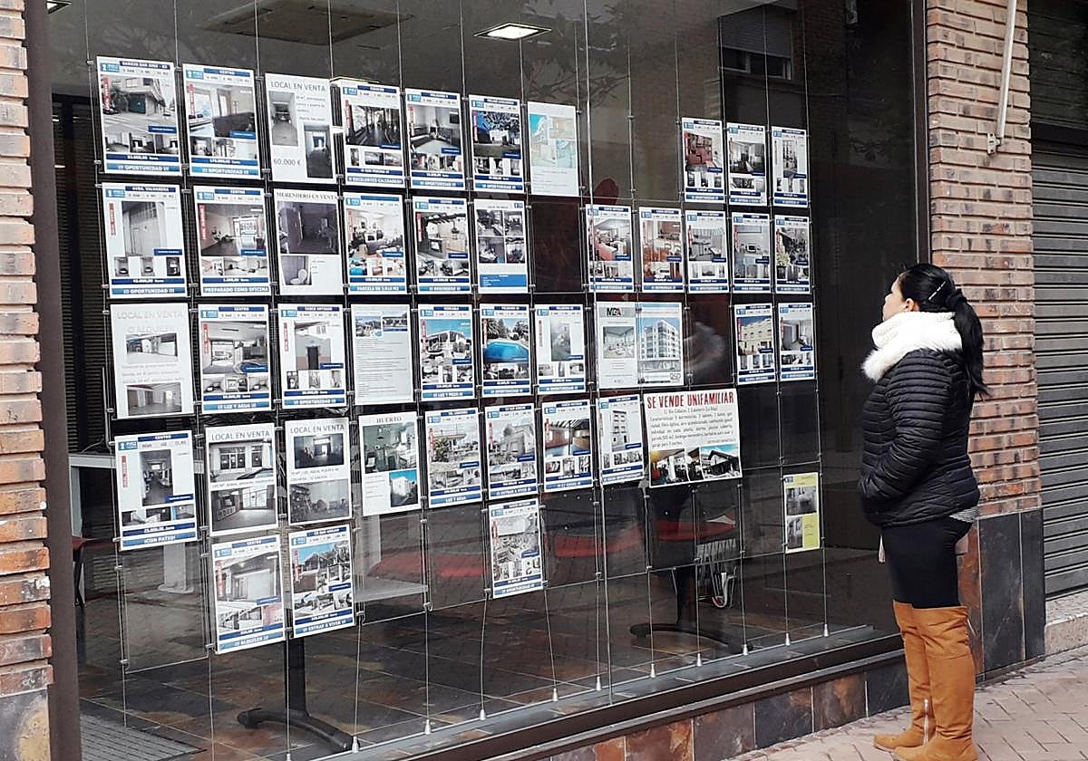 Ofertas de pisos en el escaparate de una inmobiliaria.