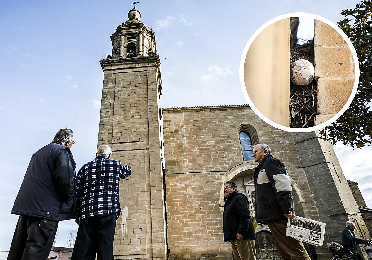 Varios vecinos observan la torre de la iglesia de Nuestra Señora la Blanca, de Agoncillo, en 2019. En el detalle, un balón incrustrado en el espacio entre la iglesia y la torre.