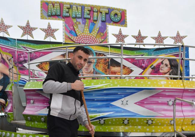 Un feriante, limpiando ayer el acceso a la atracción del 'Meneito'.