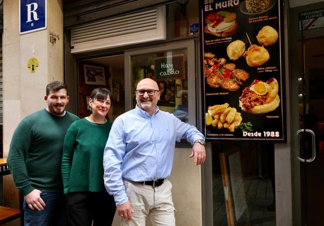 José Antonio y Noelia, nuevos propietarios de El Muro, junto a Adolfo, en la puerta del bar.