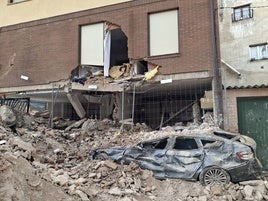 Uno de los vehículos sepultado por los escombros ya es visible. Al fondo, la casa seriamente dañada por el derrumbe de la torre.