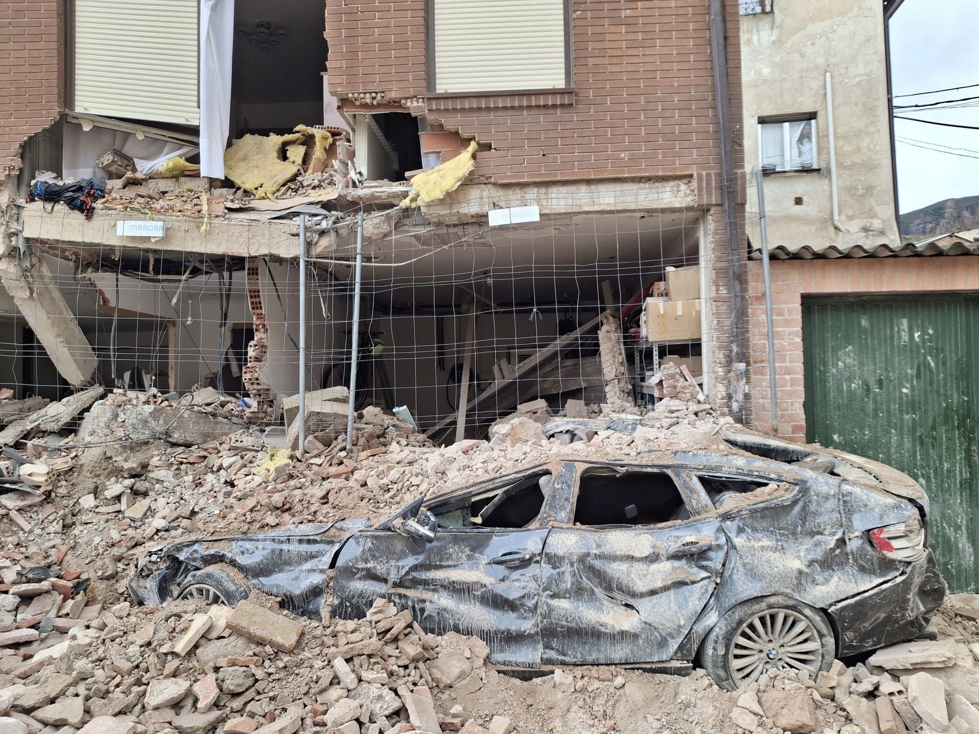 Los trabajos para despejar la zona donde cayó la iglesia dejan ver los daños en las viviendas y los primeros coches sepultados.
