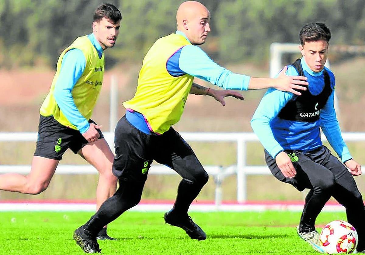 Junior con el balón, perseguido por Asier Etxaburu y Julen Hualde en un entrenamiento.