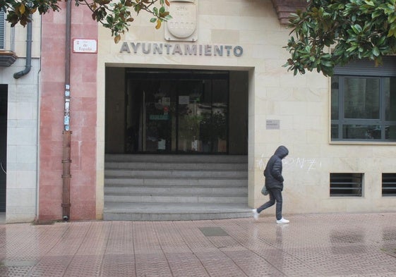 Una vecina pasea por delante de la puerta del Ayuntamiento de Nájera.