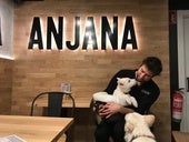 Óscar Bacaicoa, responsable del bar La Anjana, con dos perros en su establecimiento.