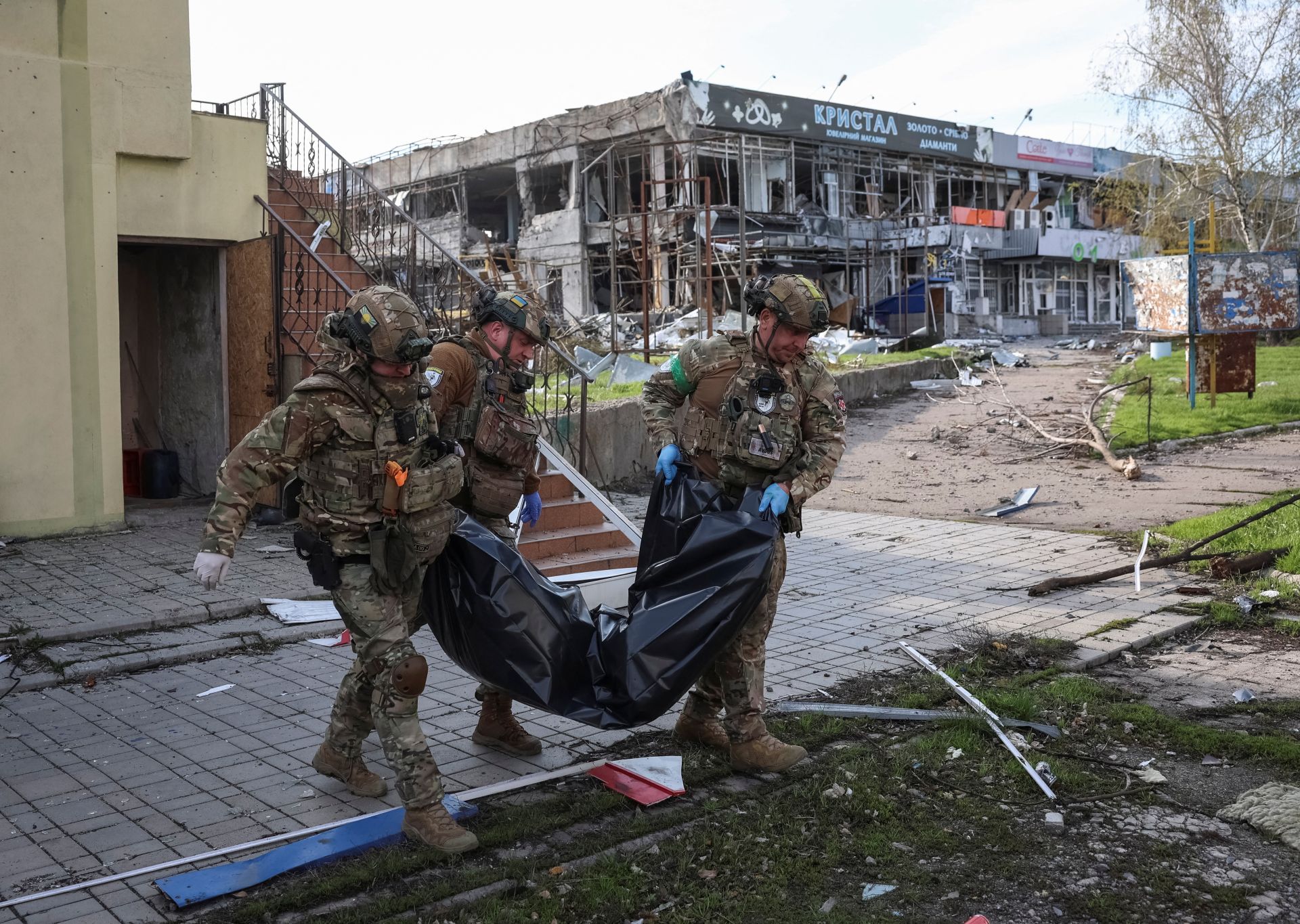 Policías ucranianos trasladan el cadáver de una víctima de los bombardeos rusos en la ciudad fronteriza de Pokrovsk, que dejó desperdigados los cuerpos de los 34 civiles asesinados.