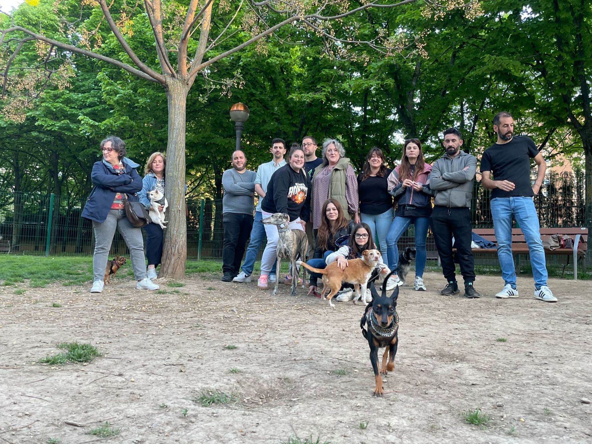 Un grupo de dueños de perros posa en la deteriorada zona de esparcimiento canino de Chiribitas.