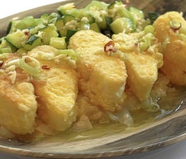 Una bandeja con tacos de bacalao rebozado y picante.
