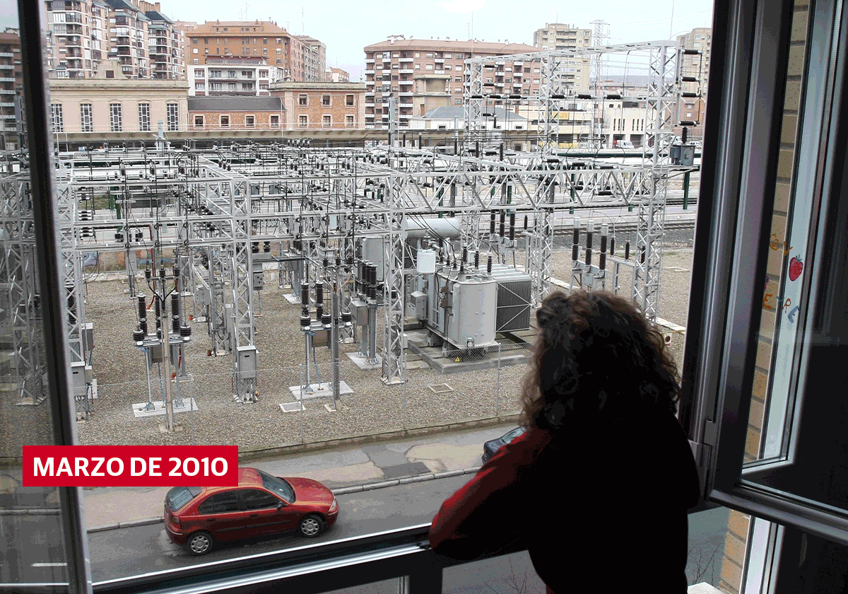 Leyre González Vicario posa 15 años después de la primera vez, dando la cara, en la ventana del salón de su casa con lo que se ve de la nueva subestación eléctrica soterrada.