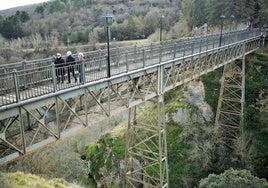 Tres vecinas de Ortigosa cruzan el puente de hierro.