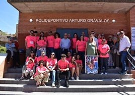 Familia de Arturo Grávalos, autoridades e integrantes de la AMPA junto a la entrada del polideportivo de Cervera, con una foto del ciclista.