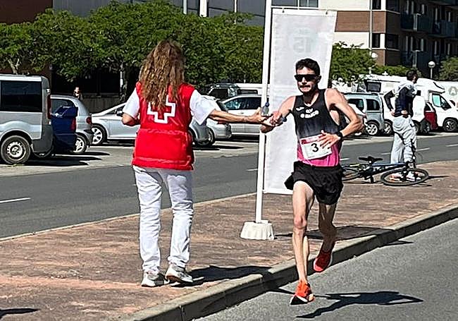 Nacho García coge agua en un avituallamiento.