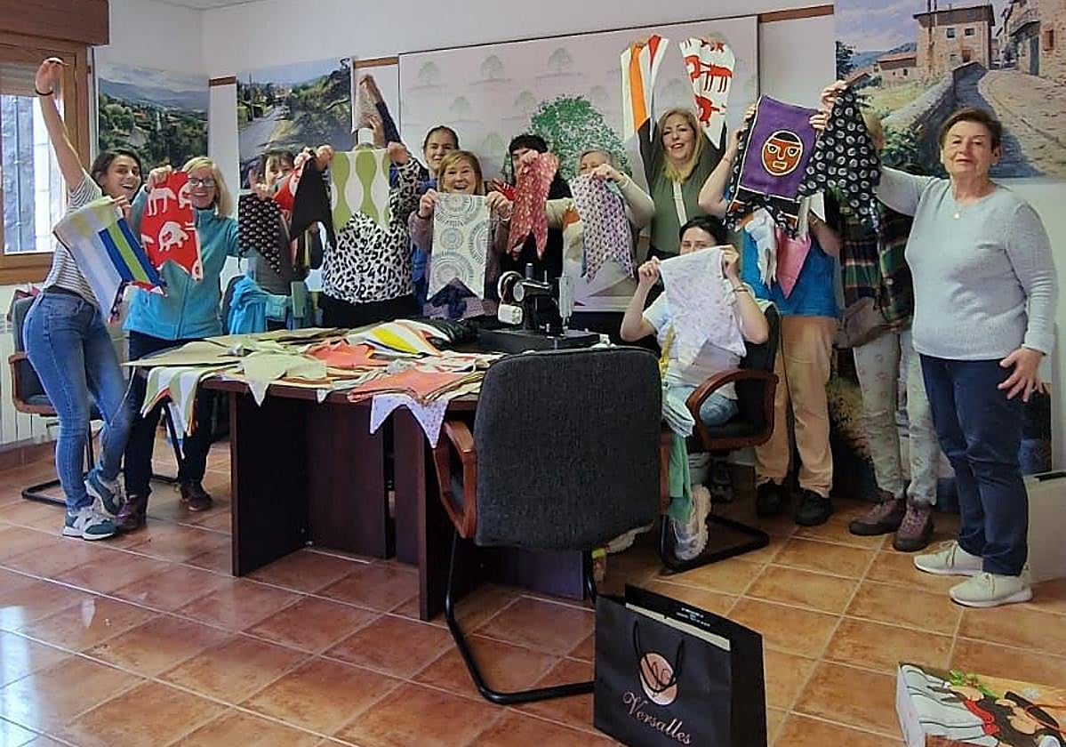 Las mujeres de El Rasillo de Cameros muestran los banderines cosidos hasta el momento.