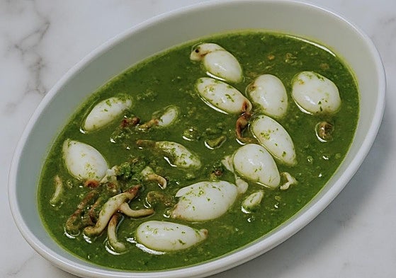 Un plato de calamares en salsa verde.