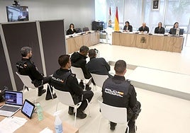 El acusado (izquierda) sentado junto a su intérprete en la sala de vistas.