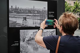 Una mujer saca su móvil para fotografiar una de las imágenes de la muestra.