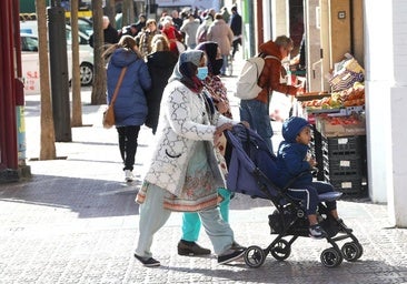 Dos mujeres extranjeras pasean un carrito en una concurrida calle de Logroño.