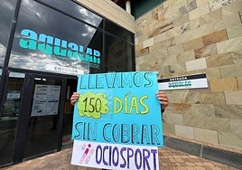 Un miembro de la plantilla de Aqualar sujeta un cartel de protesta.