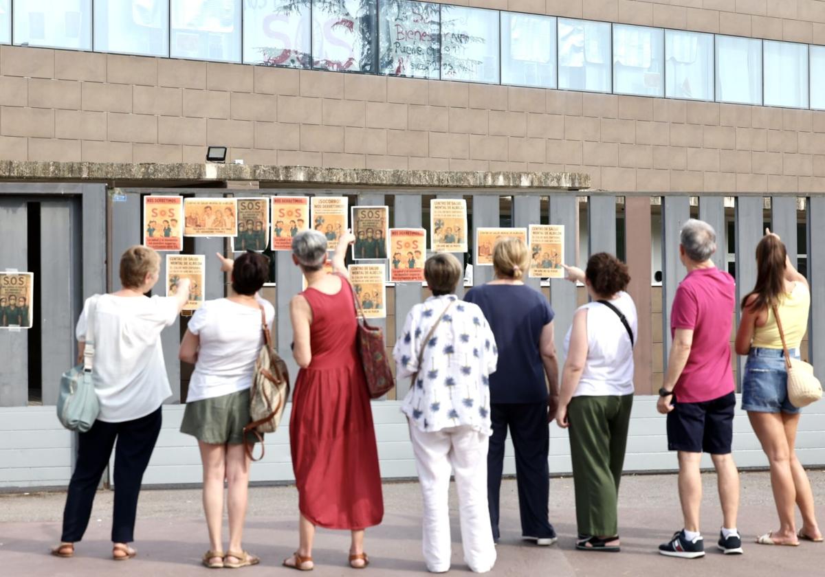Varias personas señalan las pancartas de protesta en el Centro de Salud Mental de Albelda.