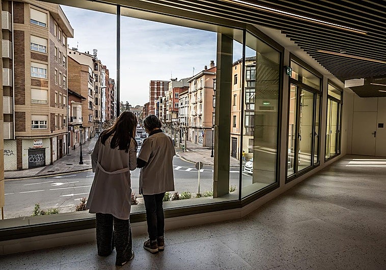 Profesionales sanitarios junto al ventanal de la fachada del nuevo centro de salud logroñés de La Villanueva.