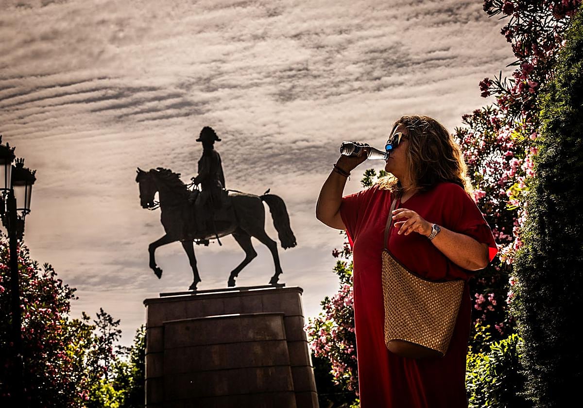 Una mujer se refresca con un botellín de agua en El Espolón.