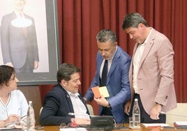 El alcalde Escobar, tarjetas roja y amarilla en la mano, conversa con concejales del PSOE antes del inicio del pleno de julio.