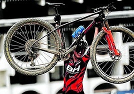 Olivia Onesti festeja su oro levantando su bicicleta.