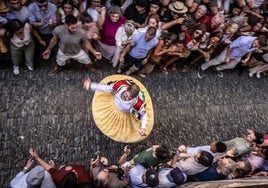 Uno de los ocho danzadores baja por la cuesta, rodeado de público.