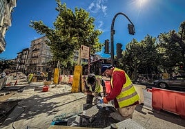 Dos operarios se afanan en una labor de las obras del cruce entre Portales y la glorieta.