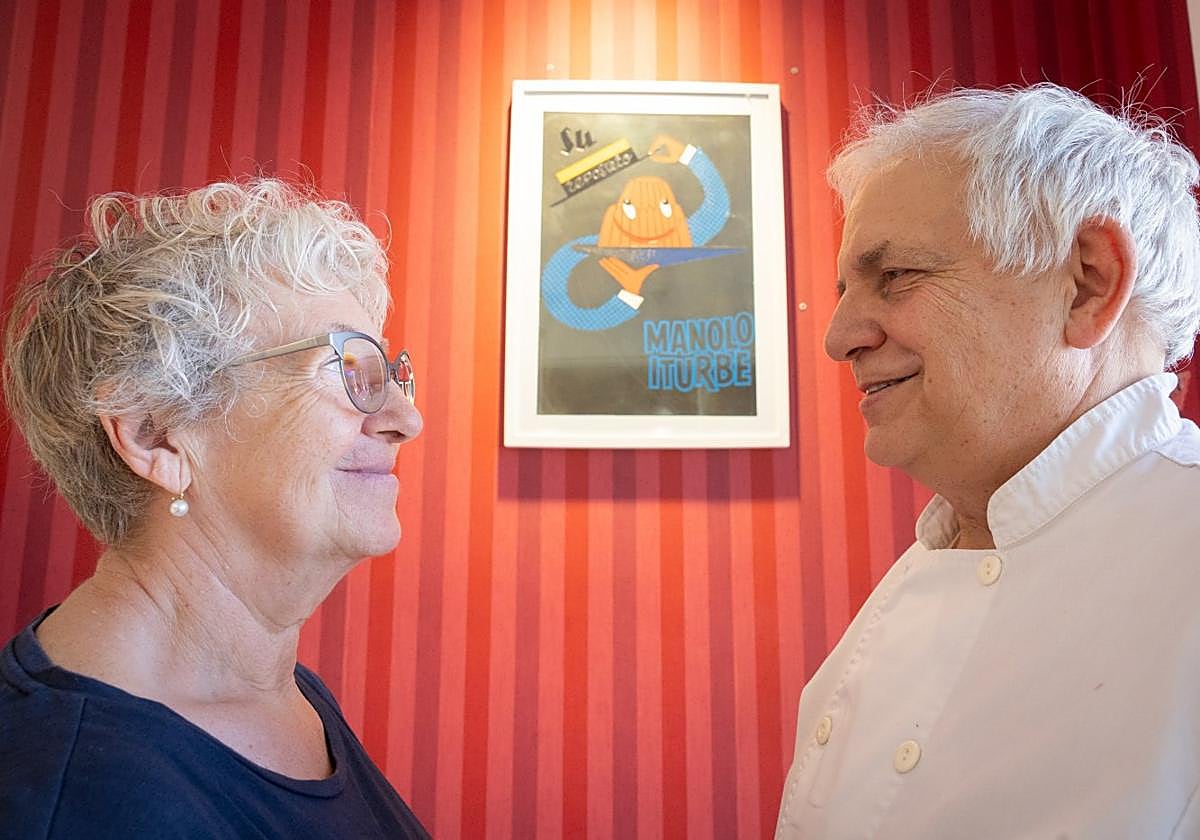 Vega Iturbe y Eduardo Zangróniz, junto al logo que desde 1966 ha acompañado a Manolo Iturbe.