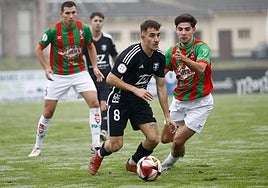Joselu Guerra, con el número 8, conduce el balón para el Langreo.