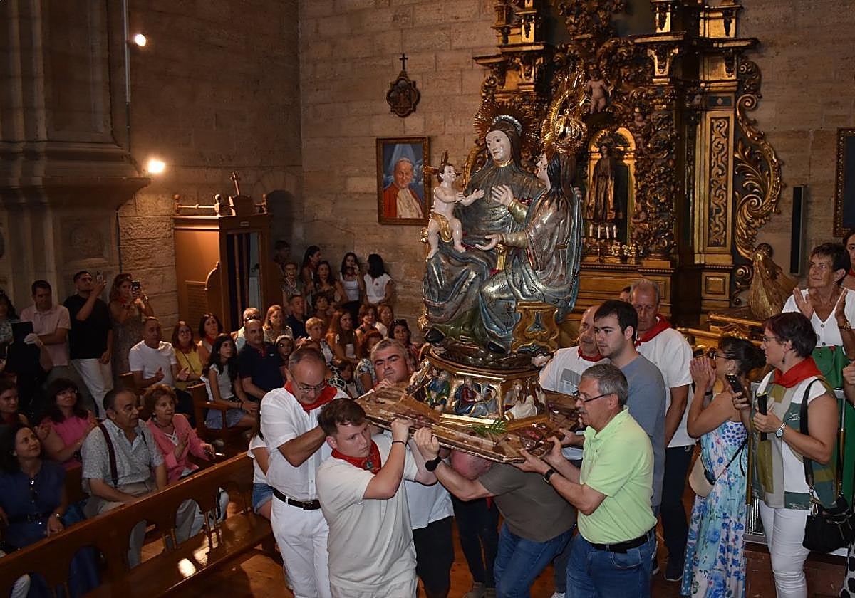 Momento en el que la imagen de Santa Ana, la Virgen María y el Niño Jesús es llevada desde sus andas hasta la plataforma para la subida al retablo mayor de la parroquia.
