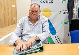Pelayo Fernández leyendo una portada en braille.